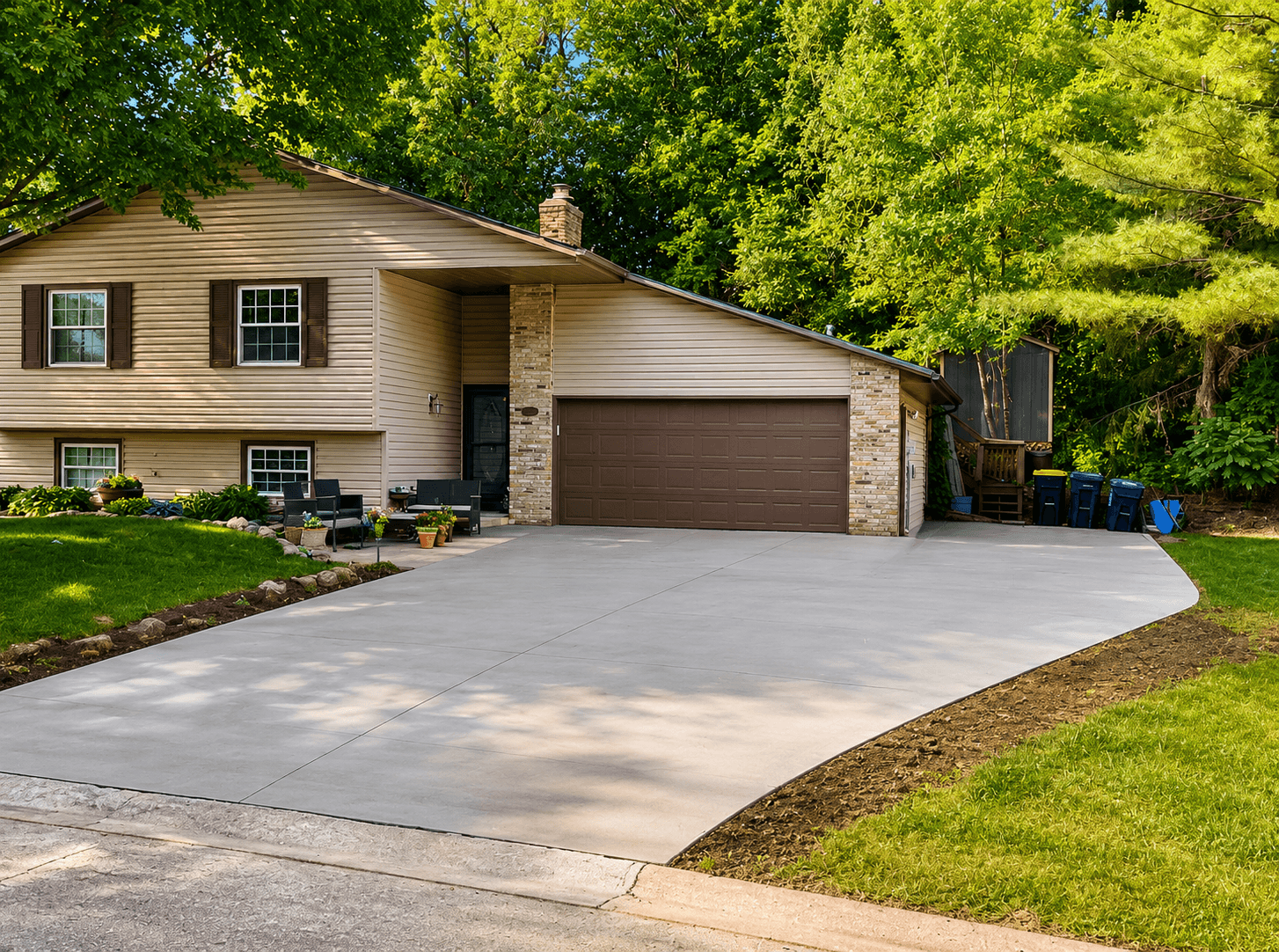 Curved concrete driveway with clean edge work and mature trees
