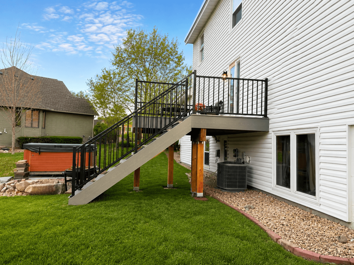 Side view of elevated deck and staircase with black railings